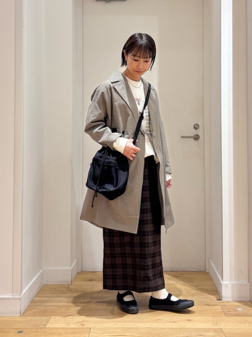 ホワイト系のTシャツ/カットソー、ベージュ系のスカート、ブラック系のショルダーバッグを着用したレディースの冬コーディネートの4枚目の写真