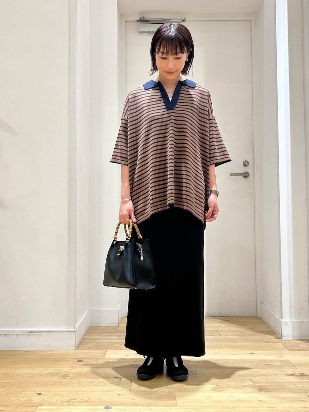 ブラック系のその他シューズ、ブラック系のスカート、ブラック系のハンドバッグを着用したレディースの夏コーディネートの2枚目の写真