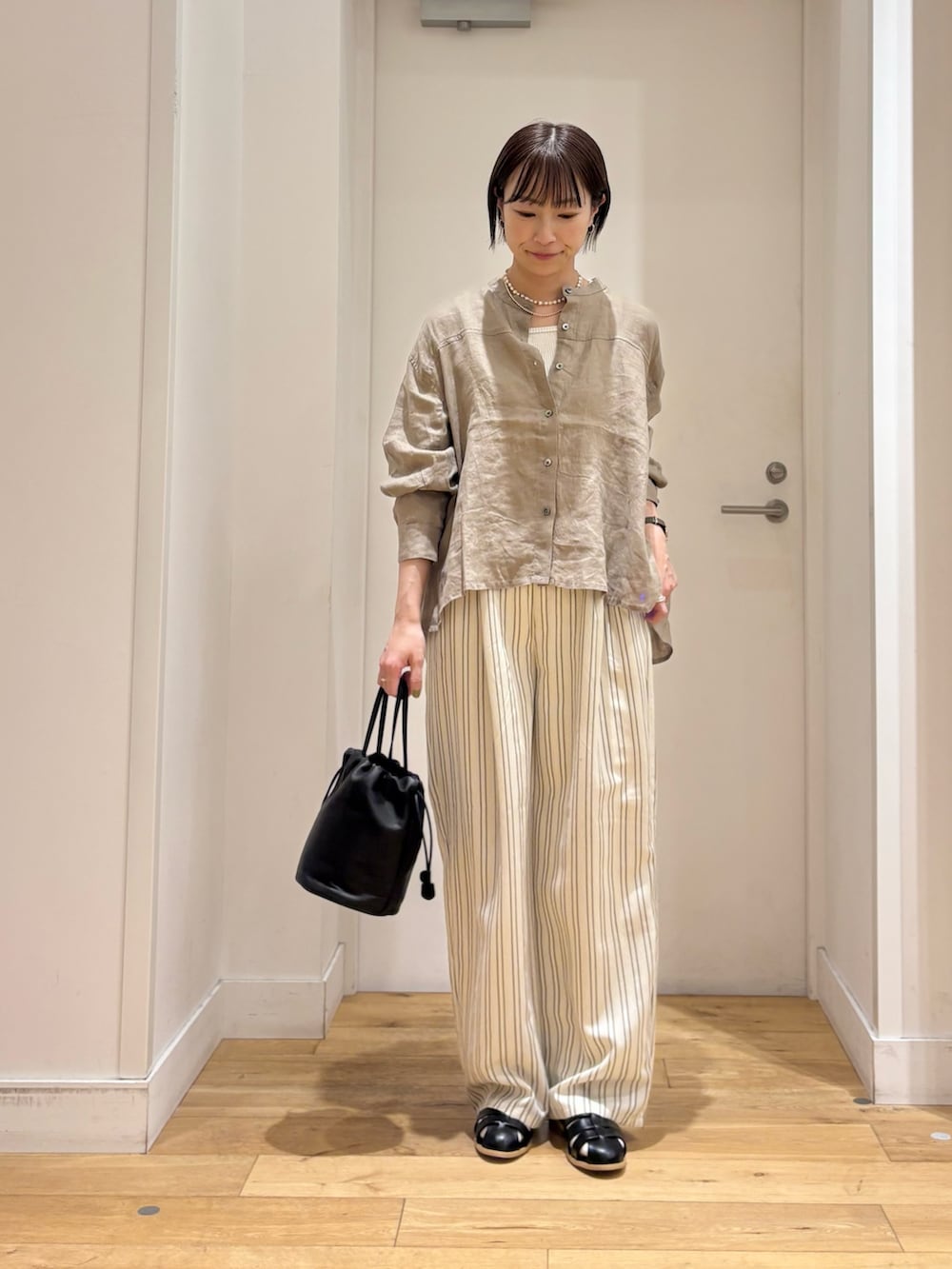 ブラウン系のシャツ/ブラウス、ホワイト系のタンクトップ、ベージュ系のその他パンツを着用したレディースの春コーディネートの2枚目の写真