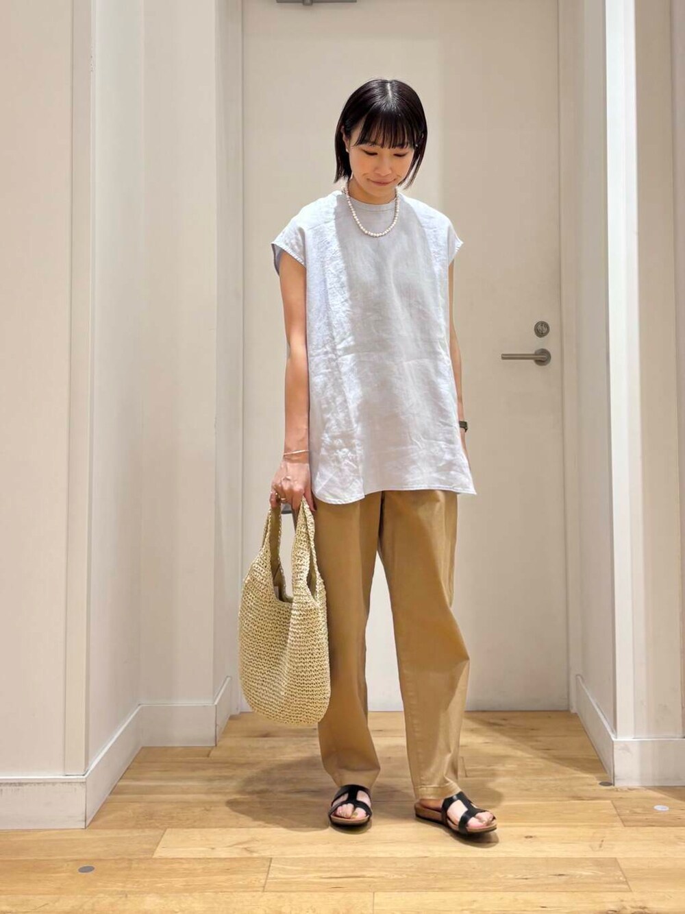 ベージュ系のトートバッグ、ベージュ系のその他パンツ、ブルー系のシャツ/ブラウスを着用したレディースの夏コーディネートの4枚目の写真