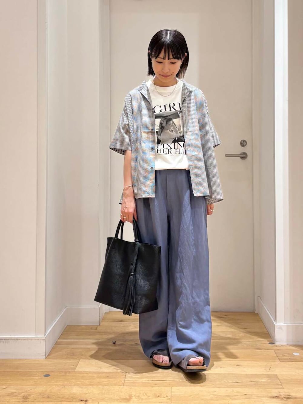 ブラック系のトートバッグ、グレー系のサンダル、ブルー系のその他パンツを着用したレディースの夏コーディネートの4枚目の写真