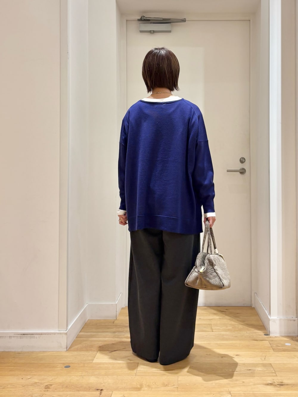 ブルー系のニット/セーター、グレー系のその他パンツ、ブラック系のパンプスを着用したレディースの秋コーディネートの4枚目の写真