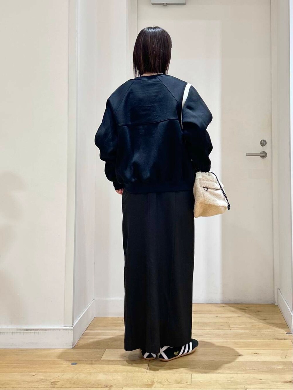 ブラック系のニット/セーター、ブラック系のワンピース、ブラック系のカーディガン/ボレロを着用したレディースの冬コーディネートの4枚目の写真