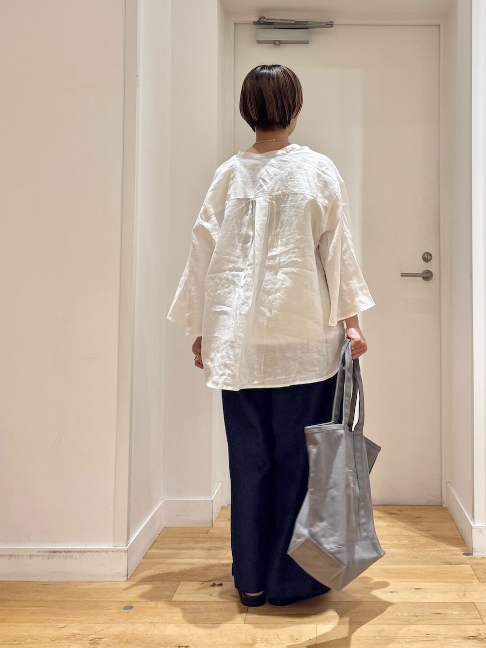 ホワイト系のシャツ/ブラウス、ホワイト系のタンクトップ、グレー系のトートバッグを着用したレディースの春コーディネートの6枚目の写真