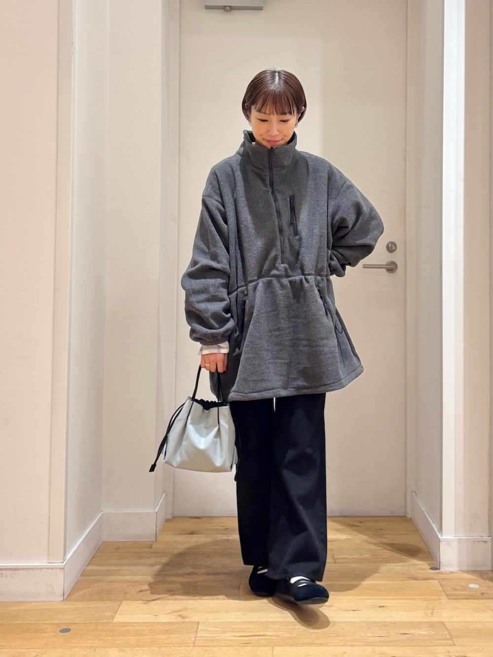 グレー系のスウェット、ブラック系のデニムパンツ、ホワイト系のシャツ/ブラウスを着用したレディースの秋コーディネートの2枚目の写真