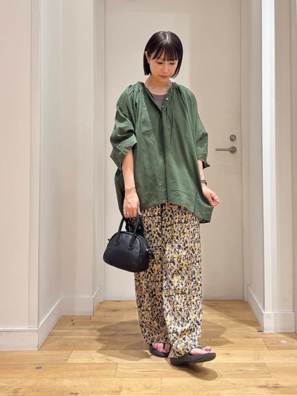 ブラック系のサンダル、グリーン系のシャツ/ブラウス、ベージュ系のその他パンツを着用したレディースの夏コーディネートの2枚目の写真