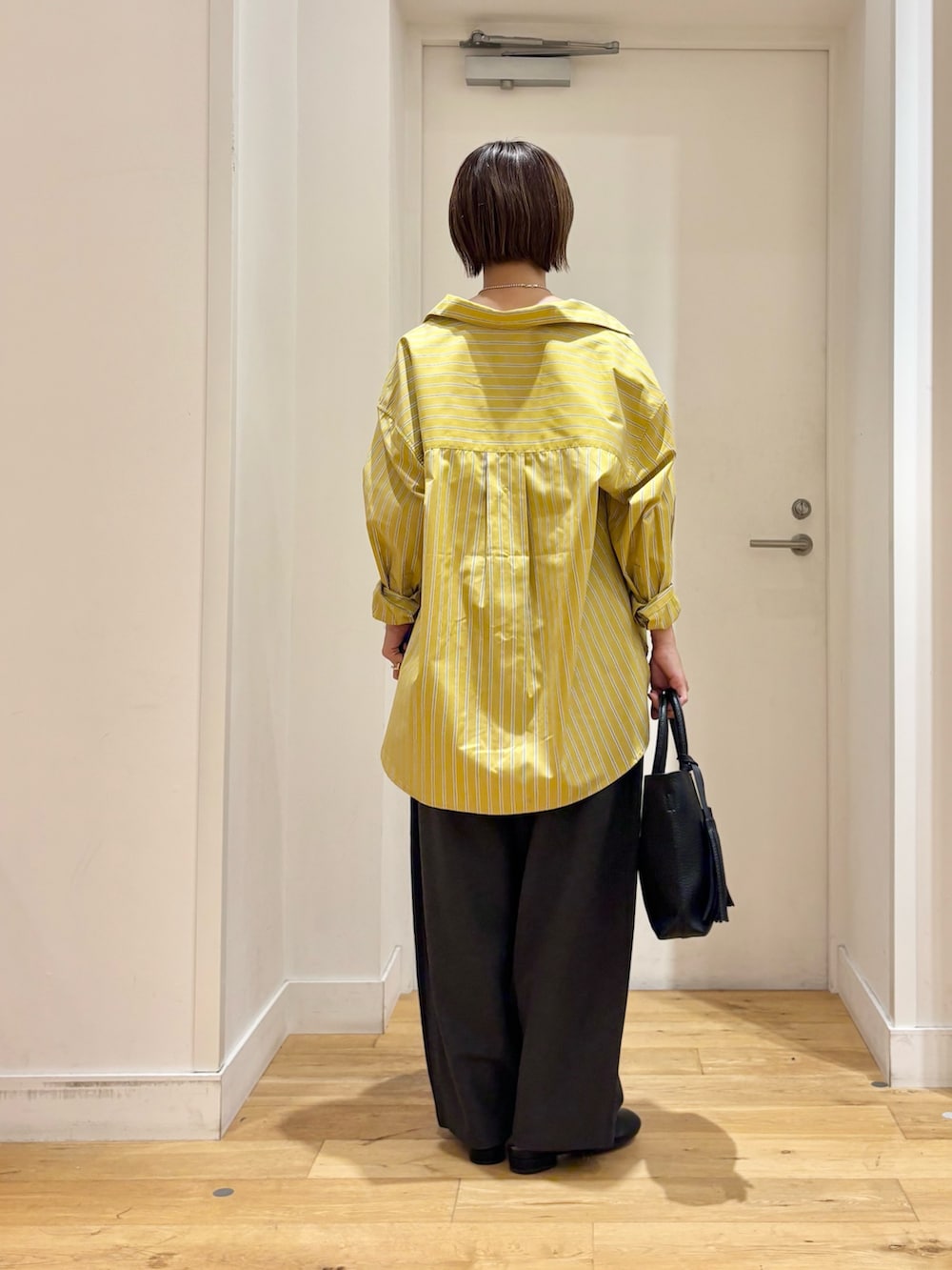イエロー系のシャツ/ブラウス、グレー系のその他パンツ、ベージュ系のタンクトップを着用したレディースの夏コーディネートの5枚目の写真