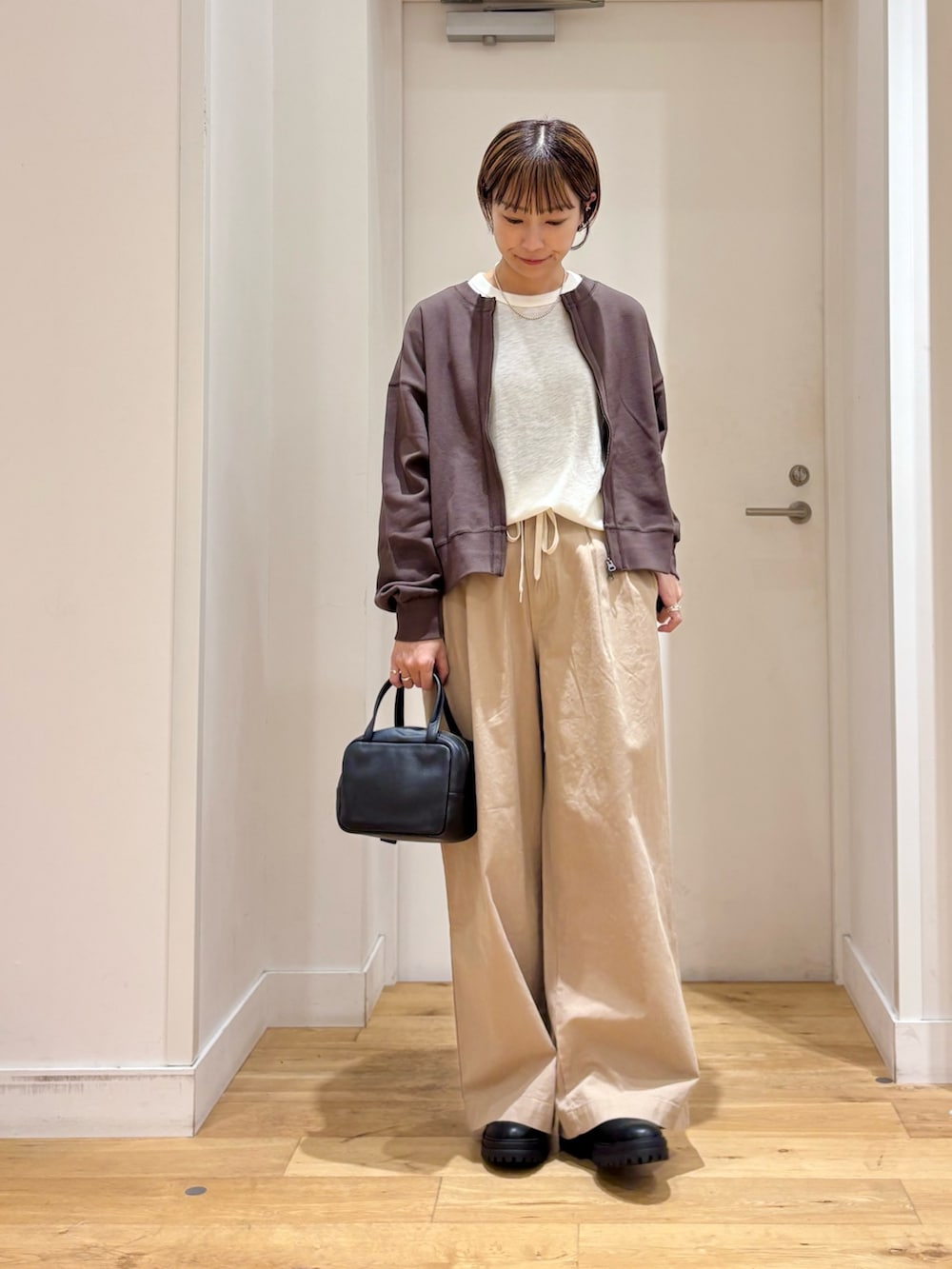 ベージュ系のその他パンツ、ホワイト系のTシャツ/カットソー、ブラウン系のカーディガン/ボレロを着用したレディースの秋コーディネートの2枚目の写真