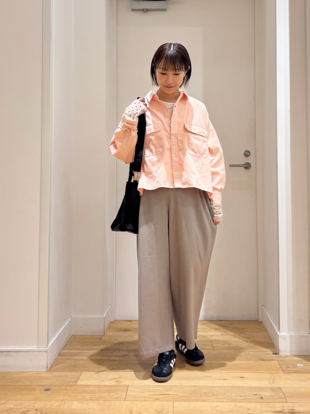 ピンク系のシャツ/ブラウス、ホワイト系のTシャツ/カットソー、ブラック系のスニーカーを着用したレディースの冬コーディネートの3枚目の写真