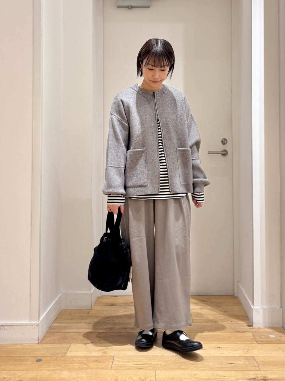 グリーン系のニット/セーター、ホワイト系のTシャツ/カットソー、グレー系のその他パンツを着用したレディースの冬コーディネートの4枚目の写真