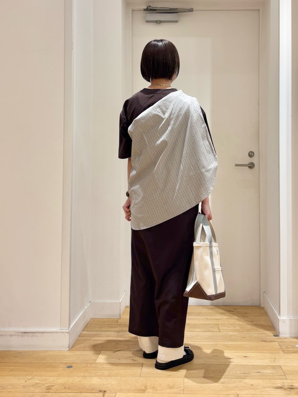 ブラウン系のワンピース、ブルー系のシャツ/ブラウス、グリーン系のトートバッグを着用したレディースの春コーディネートの6枚目の写真