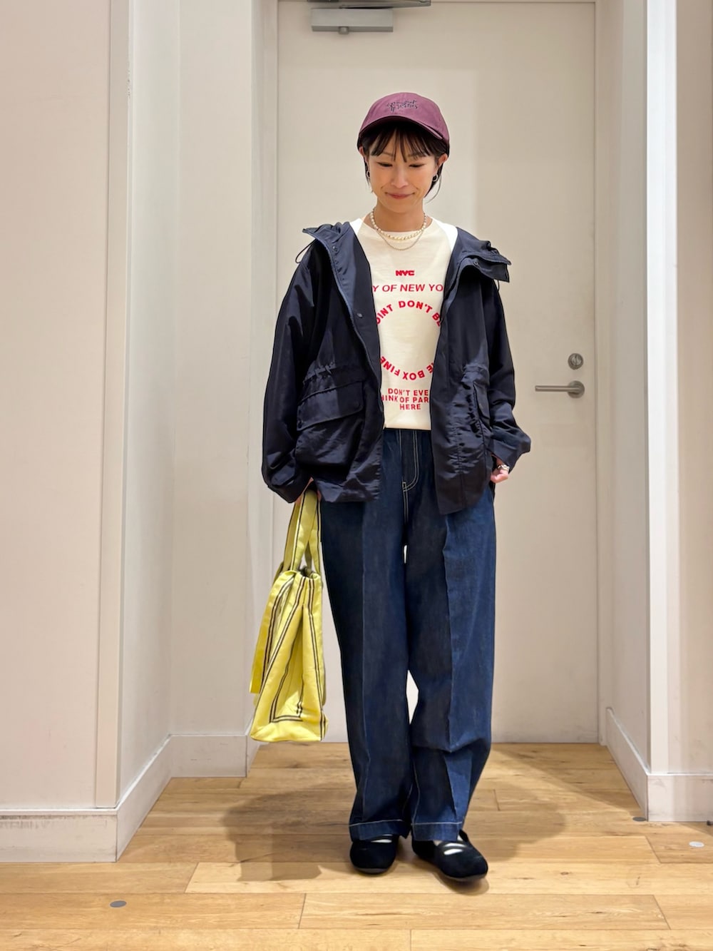 ブルー系のマウンテンパーカー、ホワイト系のTシャツ/カットソー、イエロー系のトートバッグを着用したレディースの春コーディネートの4枚目の写真