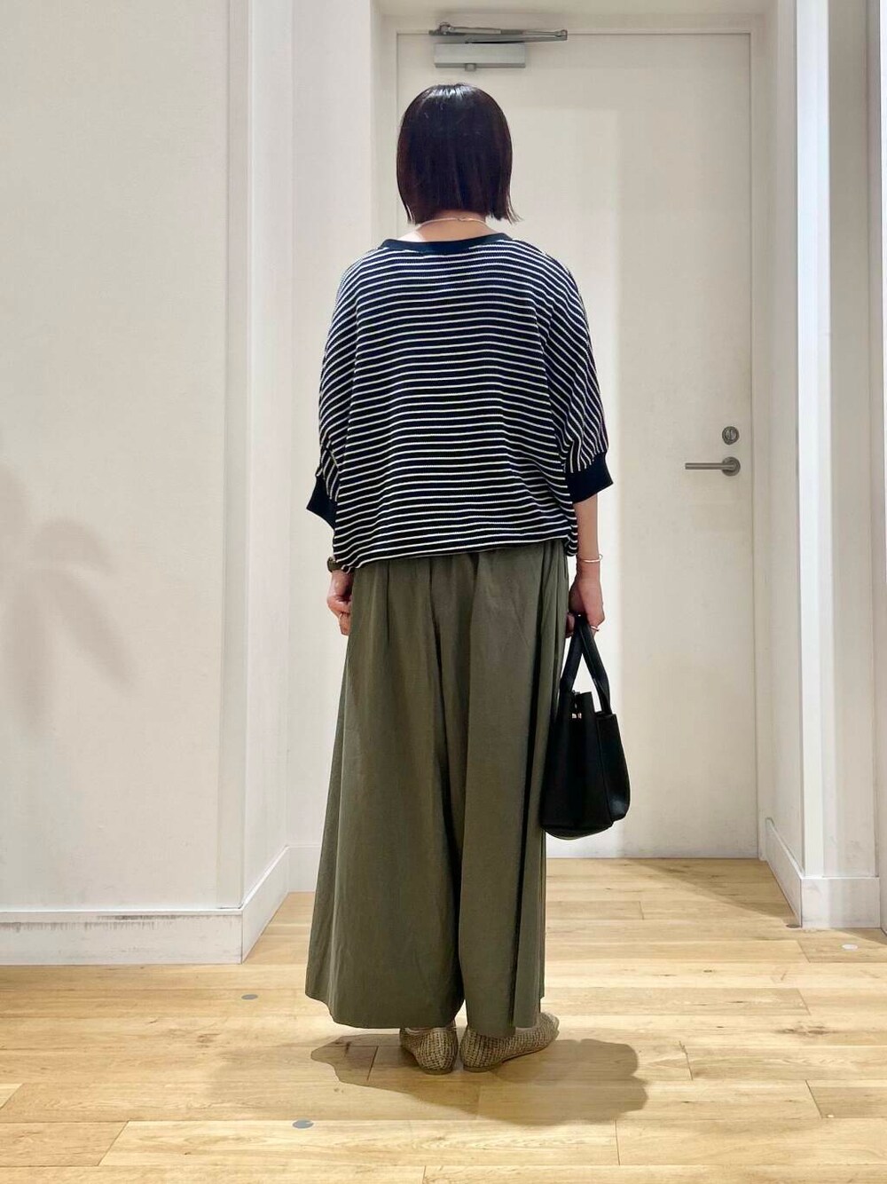 ブラック系のトートバッグ、グリーン系のその他パンツ、ベージュ系のパンプスを着用したレディースの夏コーディネートの5枚目の写真