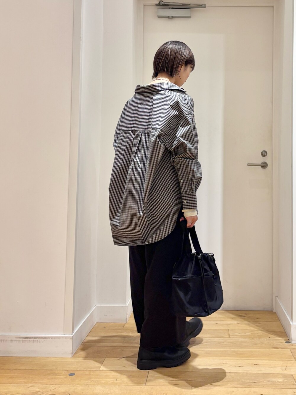 ブラック系のシャツ/ブラウス、ホワイト系のTシャツ/カットソー、ブラック系のショルダーバッグを着用したレディースの冬コーディネートの5枚目の写真