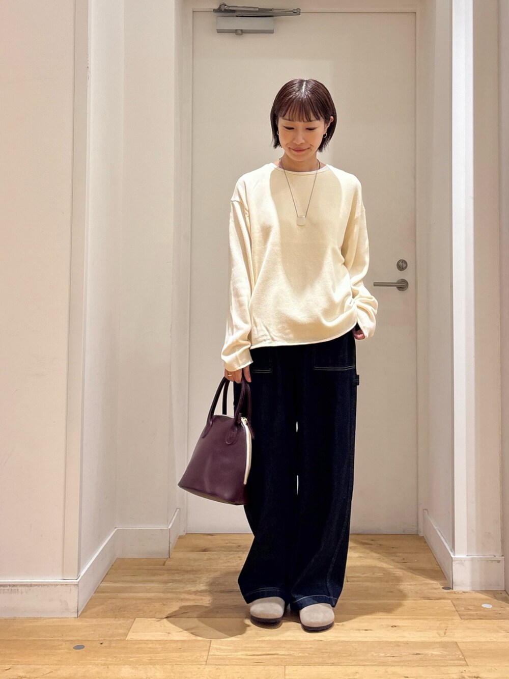ホワイト系のニット/セーター、ブルー系のデニムパンツ、ベージュ系のその他シューズを着用したレディースの秋コーディネートの4枚目の写真