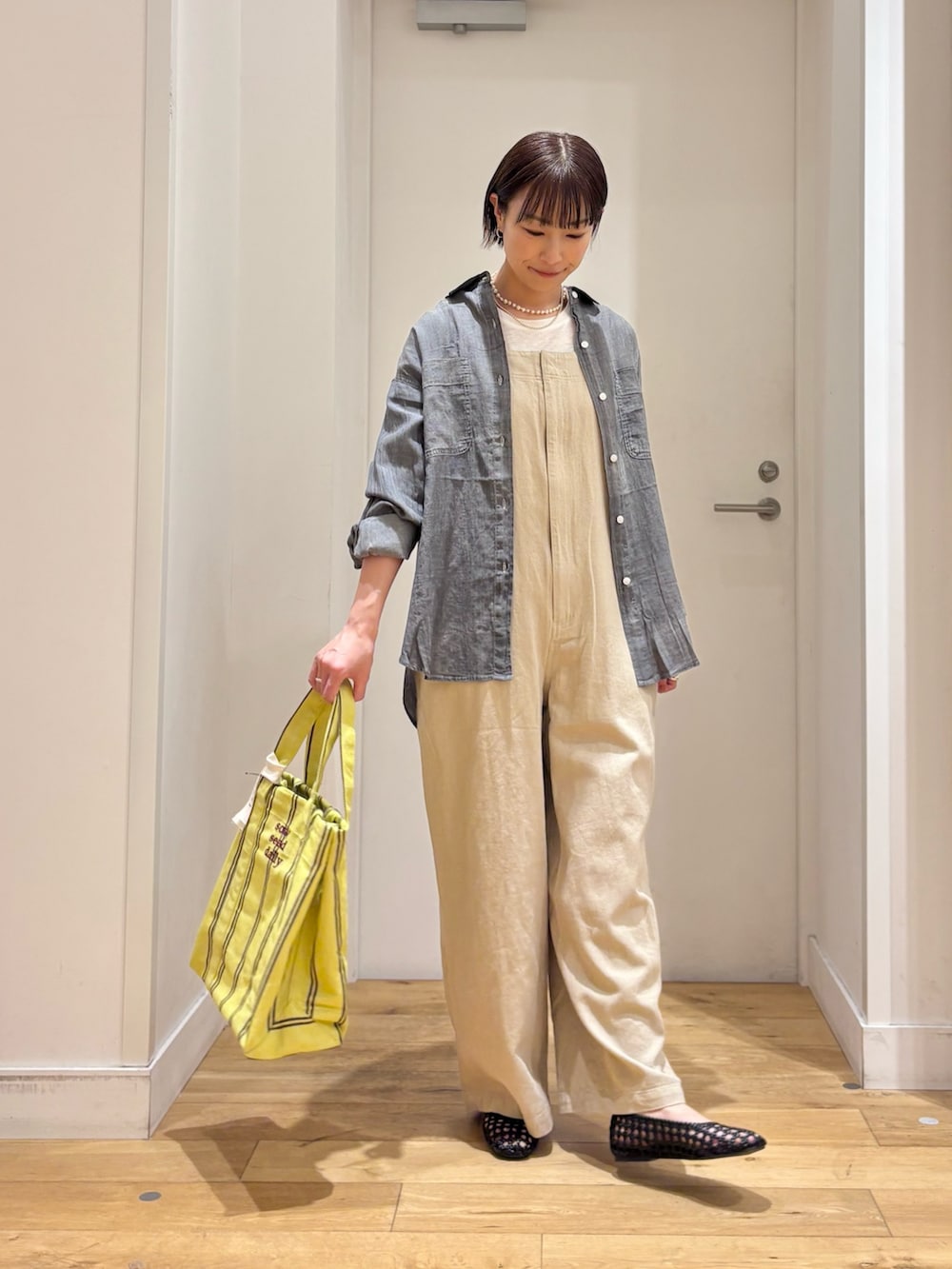 ブラック系のシャツ/ブラウス、ホワイト系のTシャツ/カットソー、ブラック系のサンダルを着用したレディースの春コーディネートの6枚目の写真