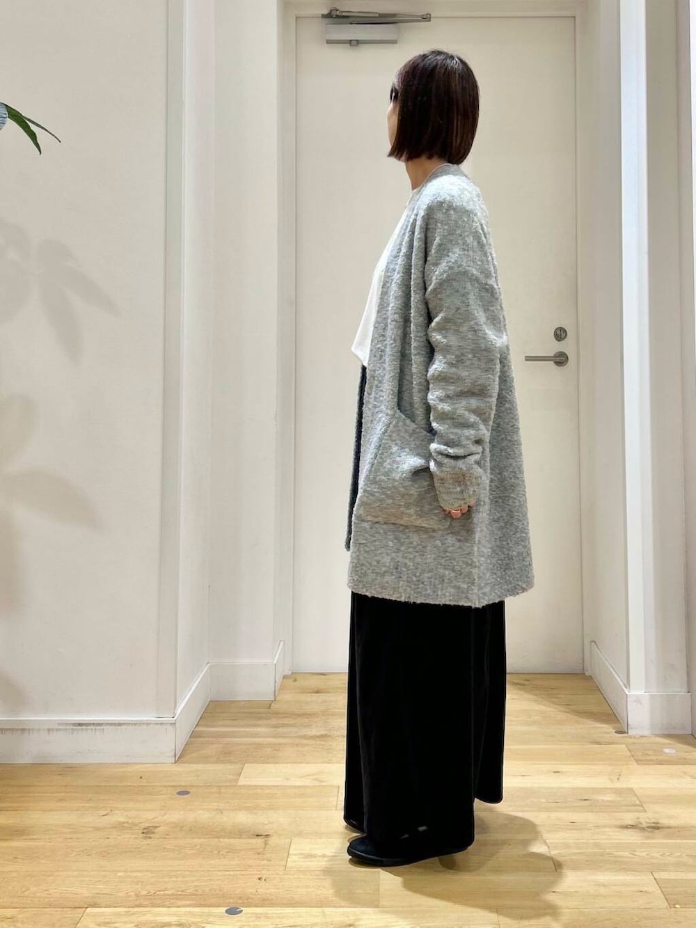 ブラック系のスニーカー、ブラック系のショルダーバッグ、ブラック系のワンピースを着用したレディースの秋コーディネートの4枚目の写真