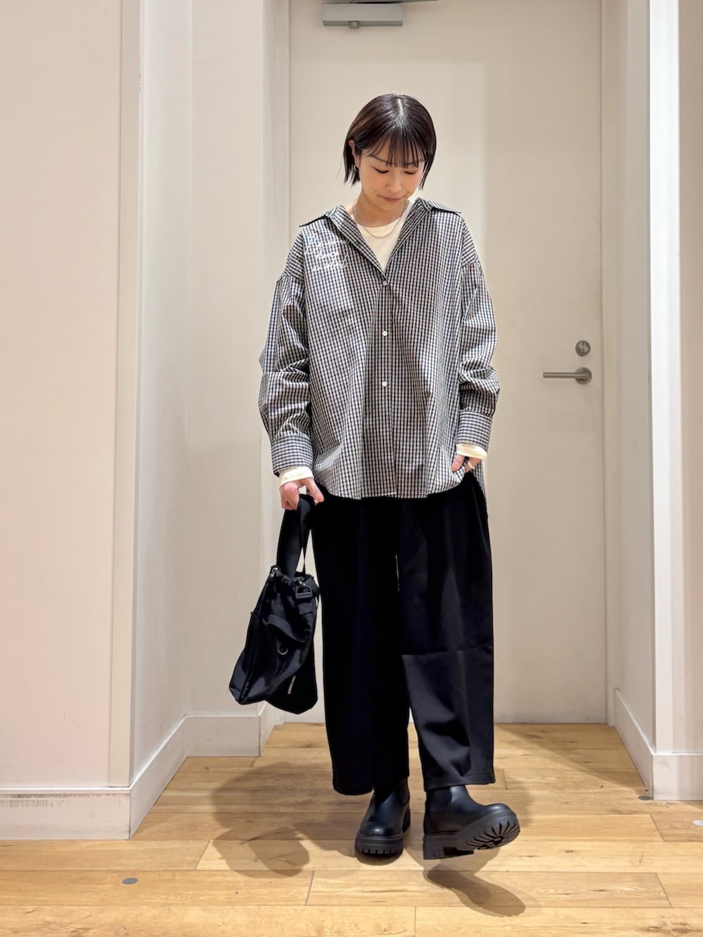 ブラック系のシャツ/ブラウス、ホワイト系のTシャツ/カットソー、ブラック系のショルダーバッグを着用したレディースの冬コーディネートの3枚目の写真