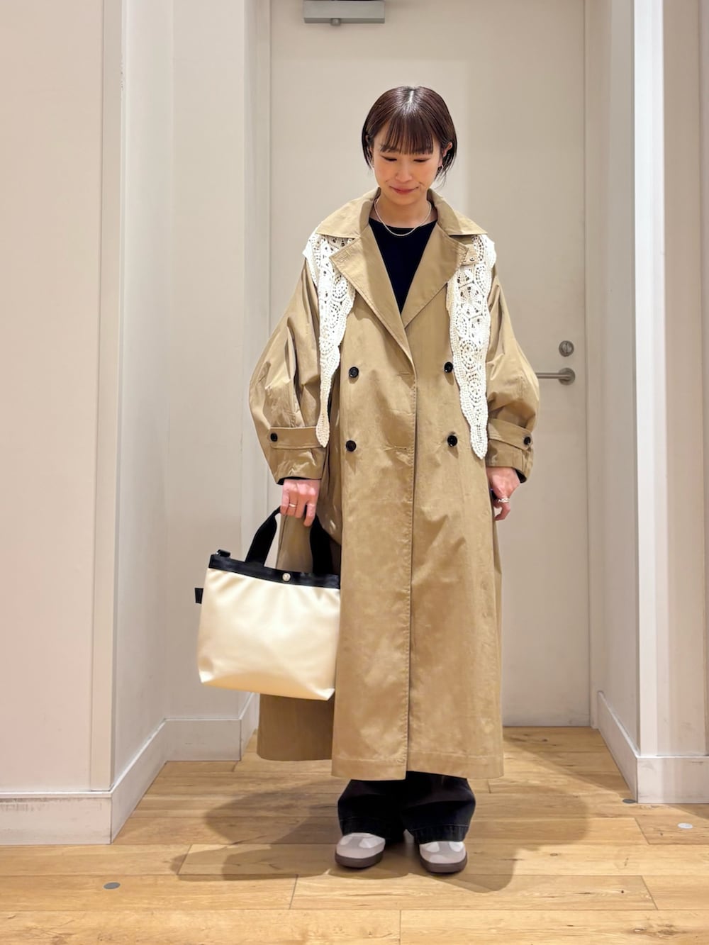 ブルー系のニット/セーター、ブラック系のデニムパンツ、ホワイト系のハンドバッグを着用したレディースの春コーディネートの5枚目の写真