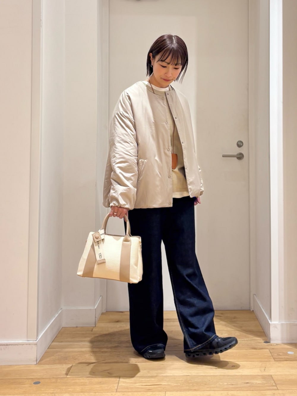 ベージュ系のブルゾン、ベージュ系のニット/セーター、ホワイト系のハンドバッグを着用したレディースの冬コーディネートの4枚目の写真