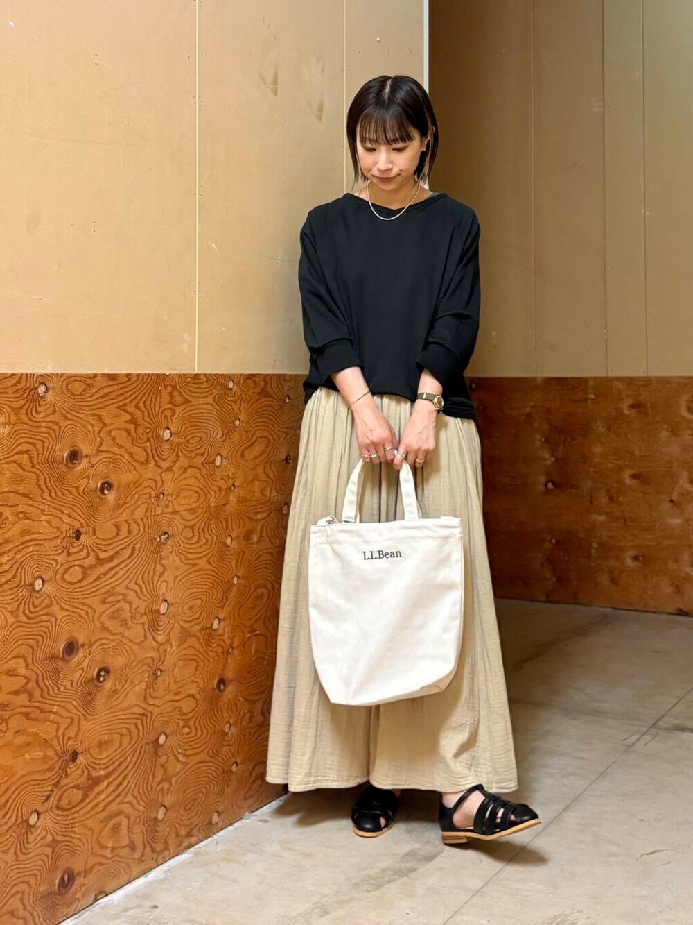 ブラック系のサンダル、ベージュ系のスカート、ブラック系のTシャツ/カットソーを着用したレディースの春コーディネートの3枚目の写真