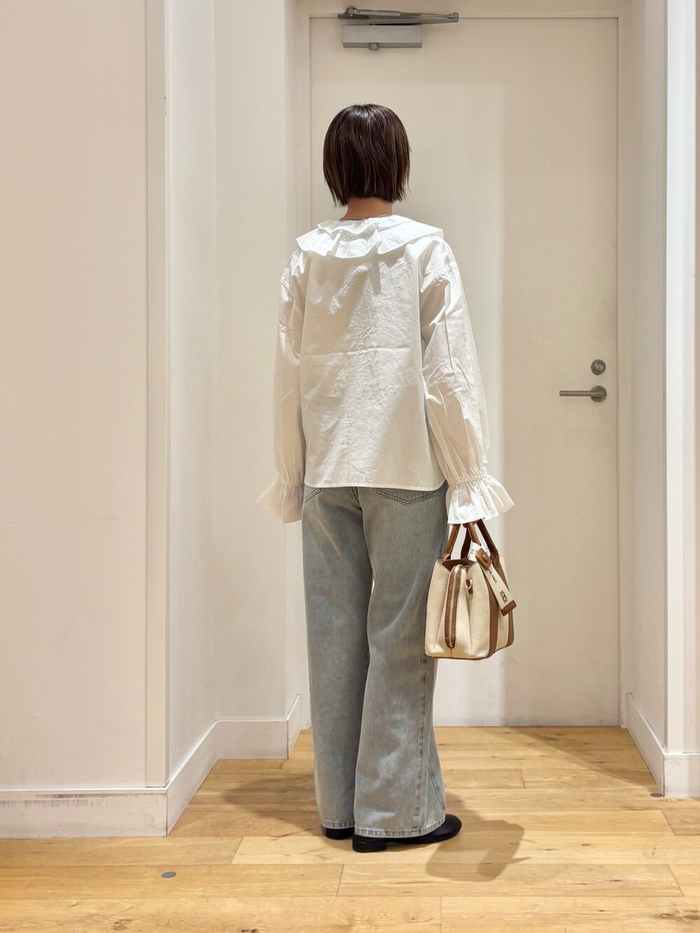 ホワイト系のシャツ/ブラウス、ブルー系のデニムパンツ、ブラック系のその他シューズを着用したレディースの秋コーディネートの5枚目の写真