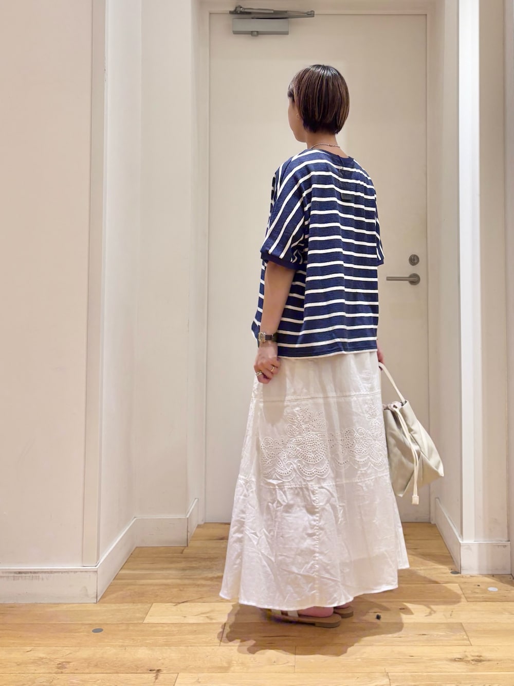 ブルー系のTシャツ/カットソー、ホワイト系のスカート、ホワイト系のショルダーバッグを着用したレディースの夏コーディネートの6枚目の写真