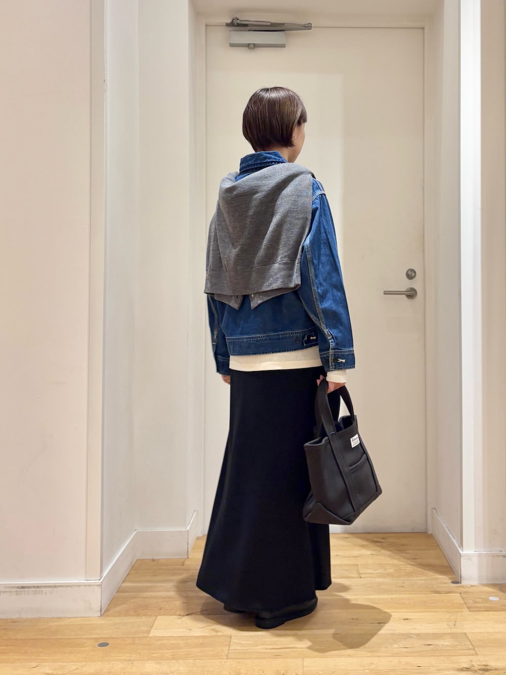 グレー系のカーディガン/ボレロ、ブルー系のデニムジャケット、ブラック系のローファーを着用したレディースの秋コーディネートの6枚目の写真