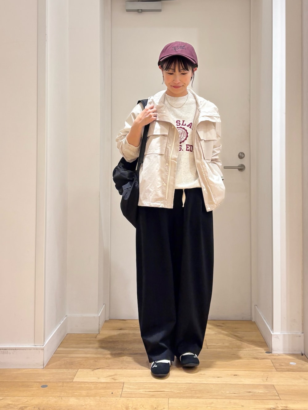 ホワイト系のナイロンジャケット、ブラック系のその他パンツ、ブラック系のスニーカーを着用したレディースの春コーディネートの5枚目の写真
