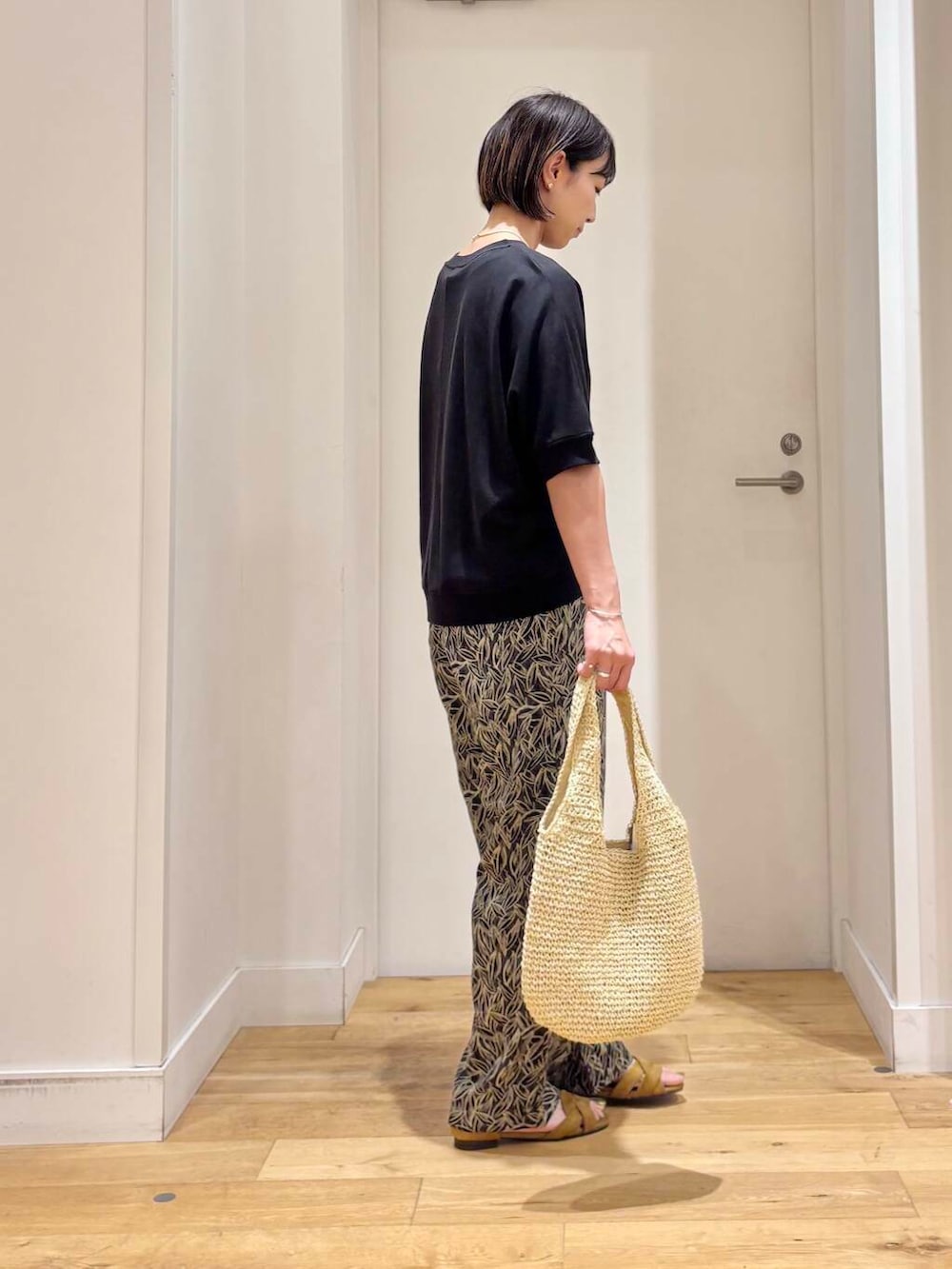 ベージュ系のトートバッグ、イエロー系のサンダル、グレー系のその他パンツを着用したレディースの夏コーディネートの5枚目の写真