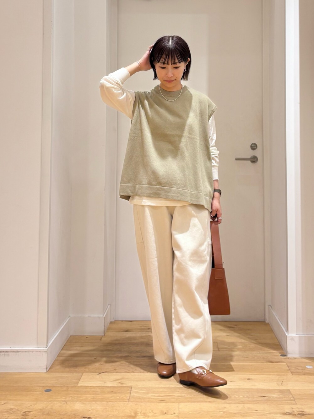 ホワイト系のTシャツ/カットソー、ブラウン系のハンドバッグを着用したレディースの夏コーディネートの3枚目の写真