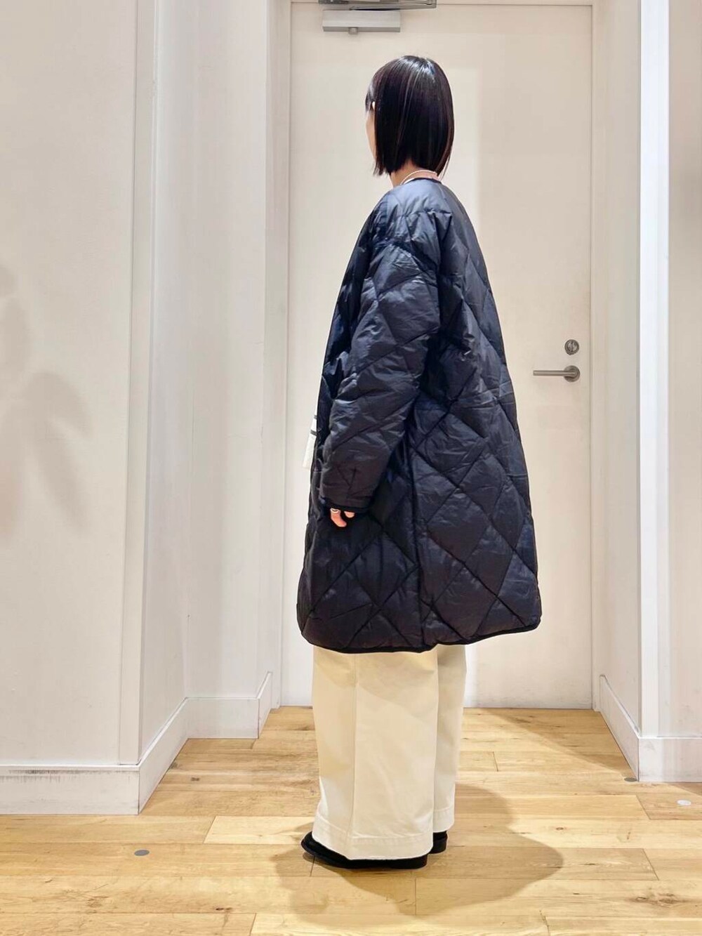 ブラック系のダウンジャケット/コート、ブルー系のショルダーバッグ、ブラック系のブーツを着用したレディースの冬コーディネートの6枚目の写真