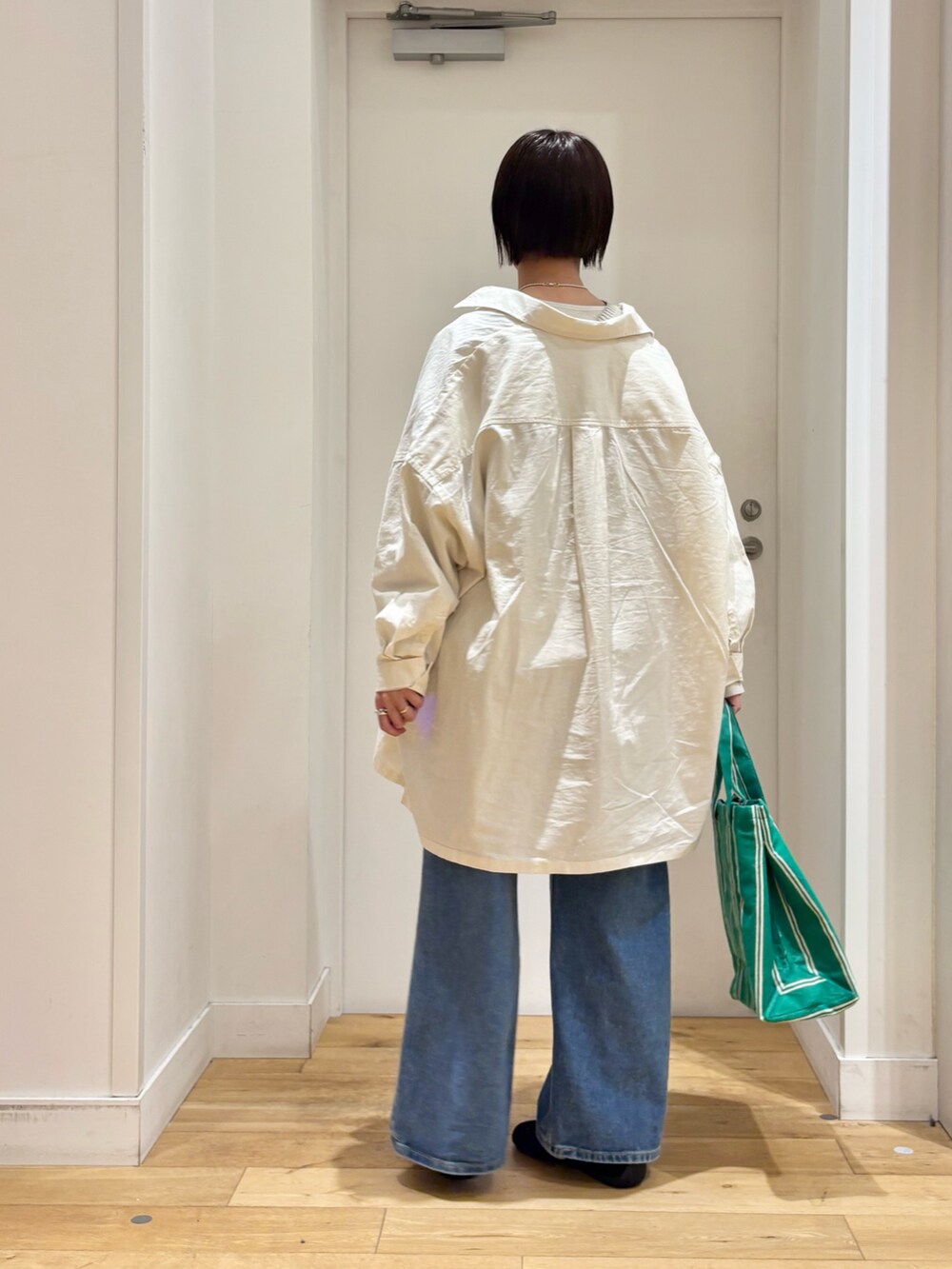 グレー系のニット/セーター、ブルー系のデニムパンツ、ブラック系のスニーカーを着用したレディースの春コーディネートの6枚目の写真