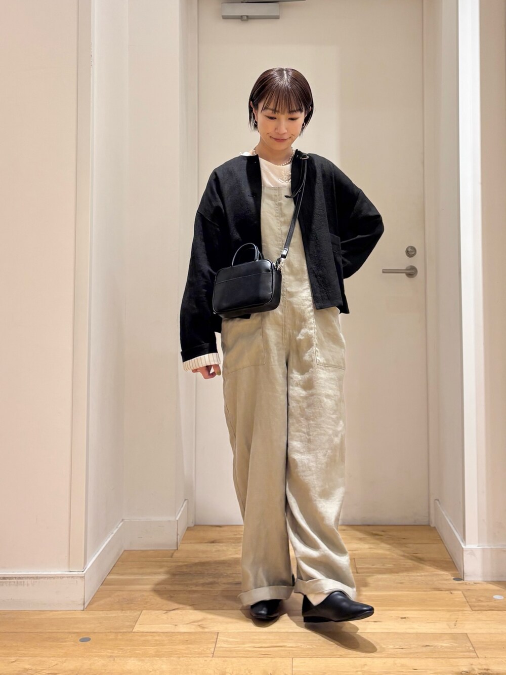 ホワイト系のシャツ/ブラウス、グレー系のサロペット/オーバーオール、ブラック系のその他シューズを着用したレディースの春コーディネートの3枚目の写真