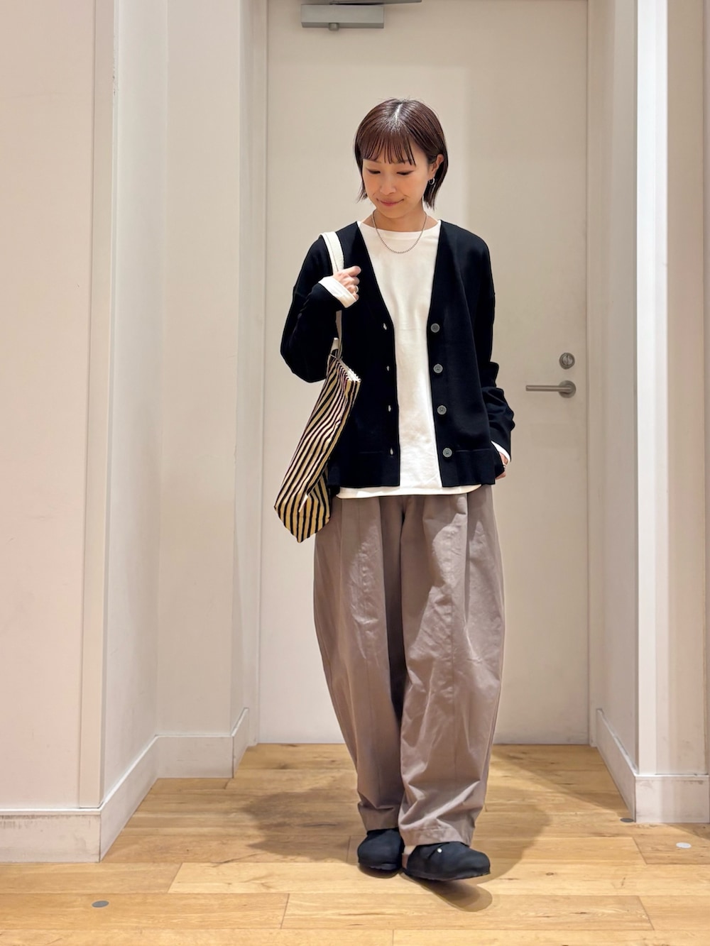ブラック系のカーディガン/ボレロ、ホワイト系のTシャツ/カットソー、ブラック系のその他シューズを着用したレディースの秋コーディネートの2枚目の写真
