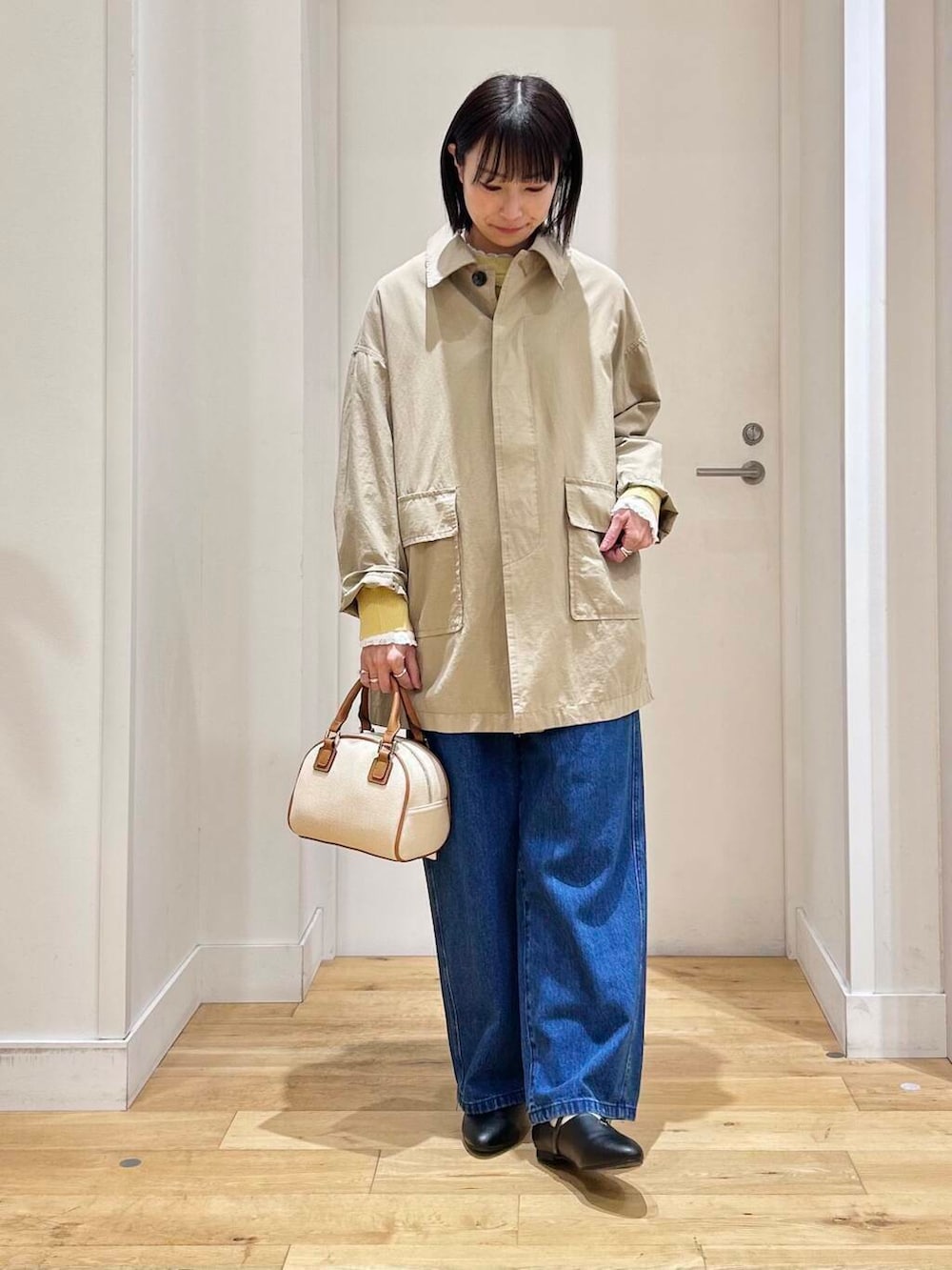 ホワイト系のシャツ/ブラウス、イエロー系のニット/セーター、ブルー系のデニムパンツを着用したレディースの冬コーディネートの5枚目の写真