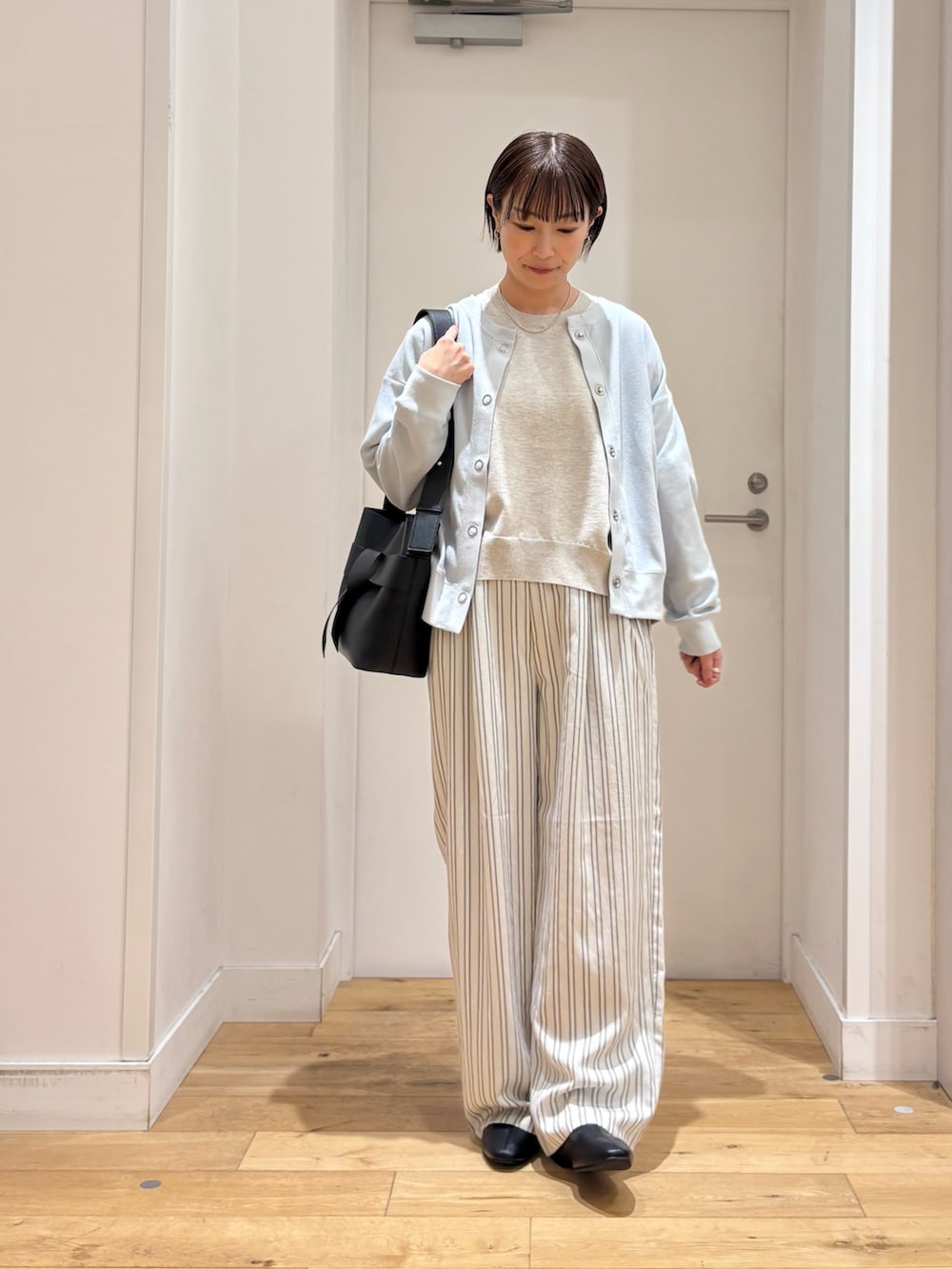 ブルー系のカーディガン/ボレロ、ベージュ系のTシャツ/カットソー、グレー系のその他パンツを着用したレディースの春コーディネートの3枚目の写真