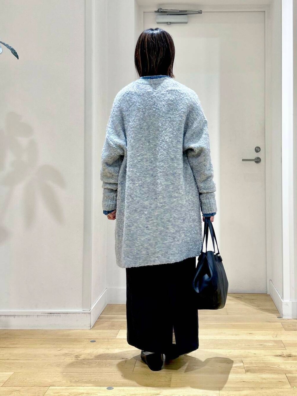 ブラック系のローファー、ブラック系のショルダーバッグ、ブルー系のスカートを着用したレディースの秋コーディネートの5枚目の写真