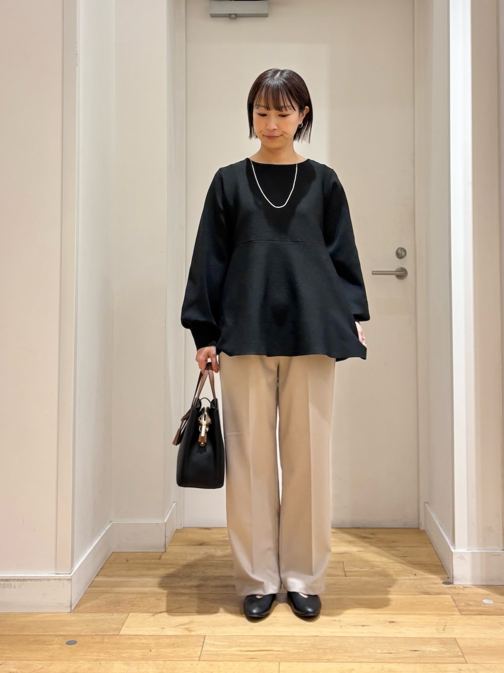 ブラック系のニット/セーター、ベージュ系のその他パンツ、ブラック系のパンプスを着用したレディースの冬コーディネートの3枚目の写真