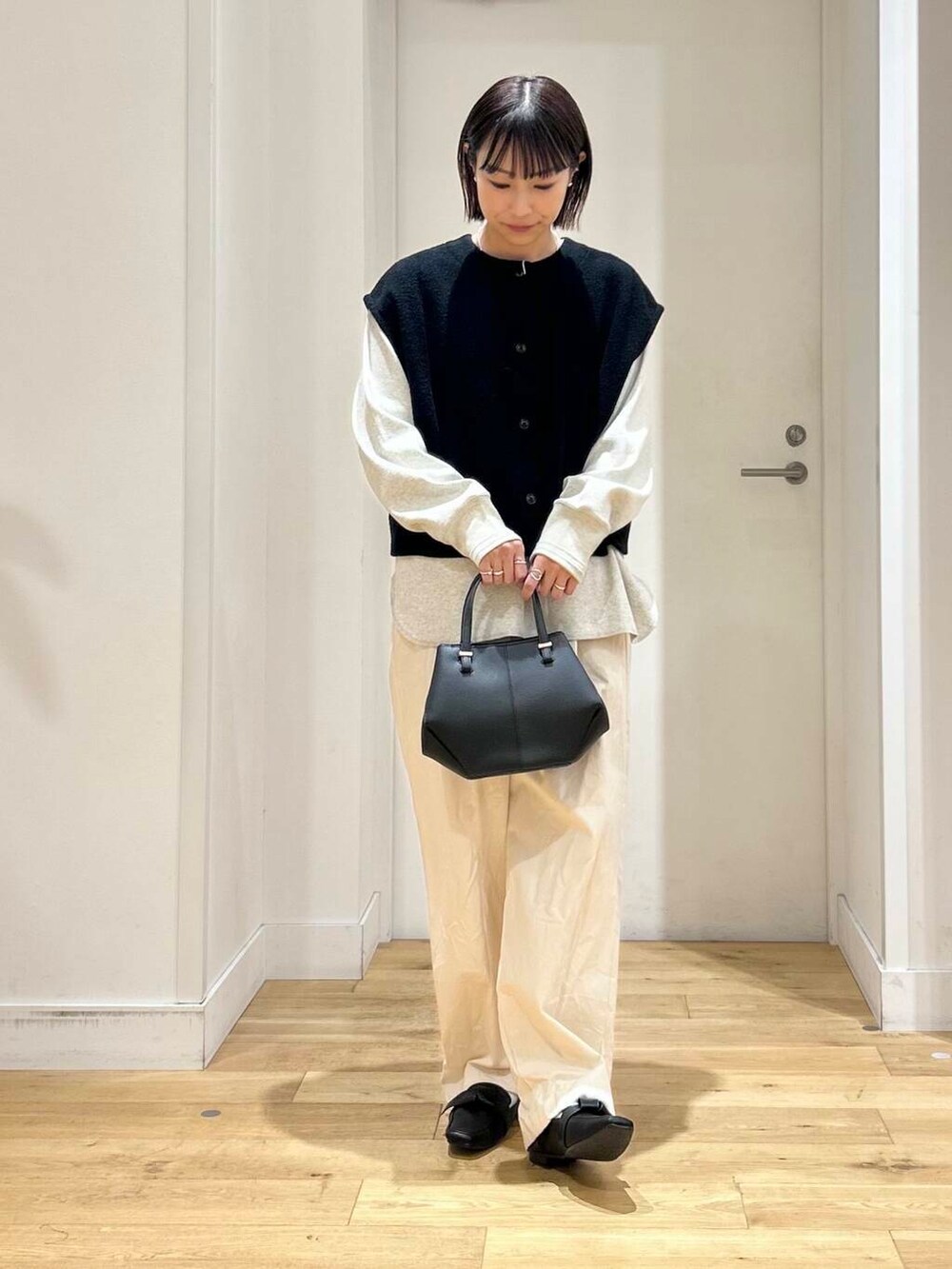 ブラック系のドレスシューズ、ベージュ系のデニムパンツ、ブラック系のショルダーバッグを着用したレディースの冬コーディネートの2枚目の写真