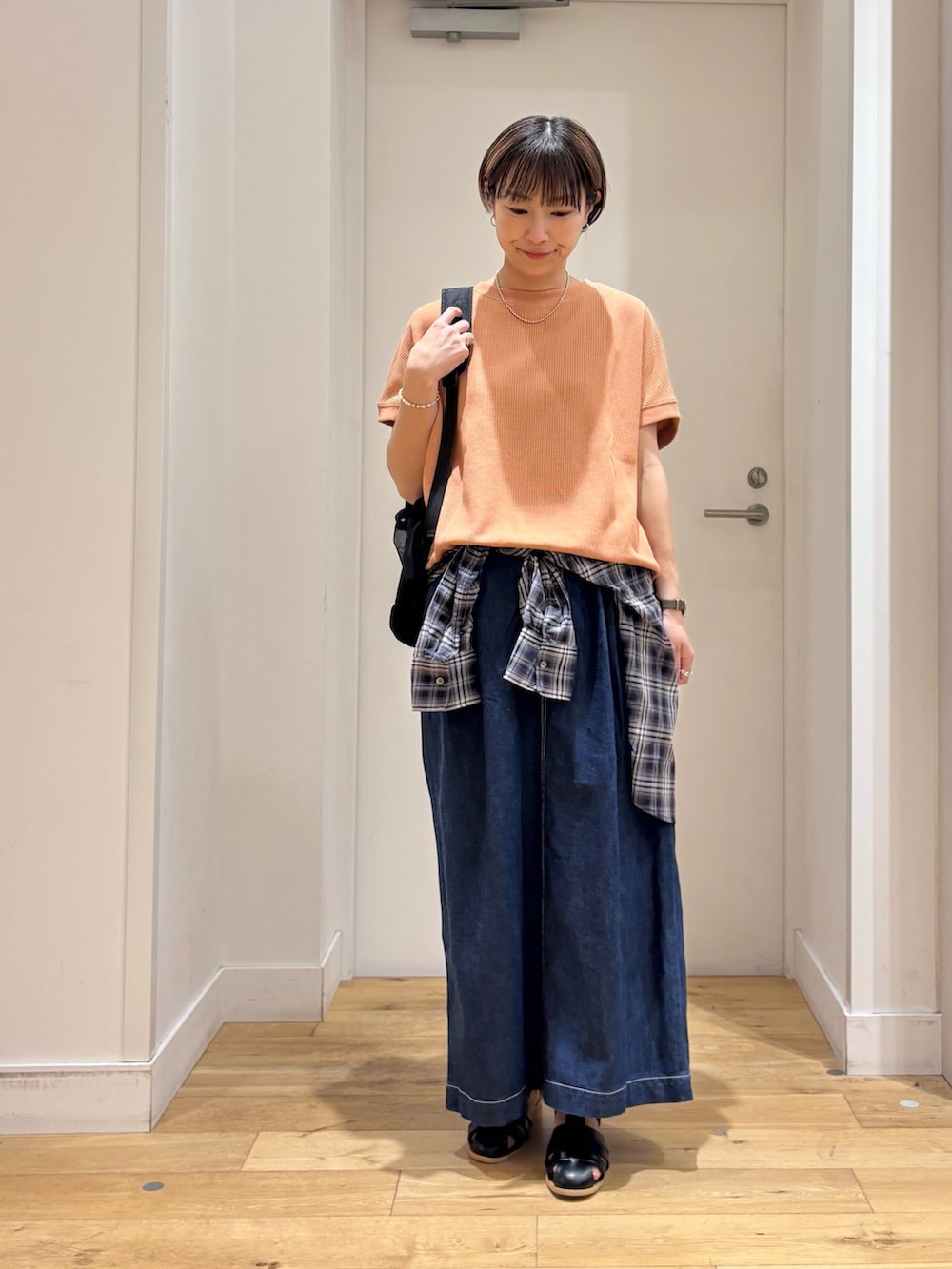 レッド系のTシャツ/カットソー、ブルー系のシャツ/ブラウス、ブルー系のスカートを着用したレディースの春コーディネートの2枚目の写真