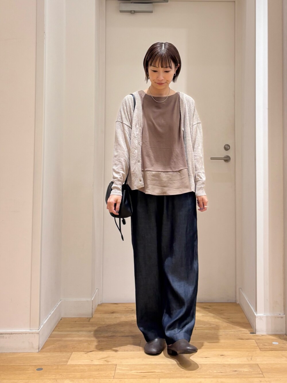 ブラウン系のTシャツ/カットソー、ブルー系のデニムパンツ、ベージュ系のカーディガン/ボレロを着用したレディースの夏コーディネートの3枚目の写真