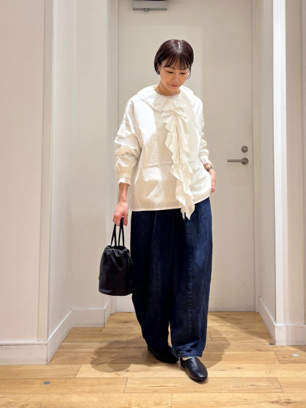 ブルー系のデニムパンツ、ブラック系のその他シューズ、ホワイト系のシャツ/ブラウスを着用したレディースの冬コーディネートの3枚目の写真