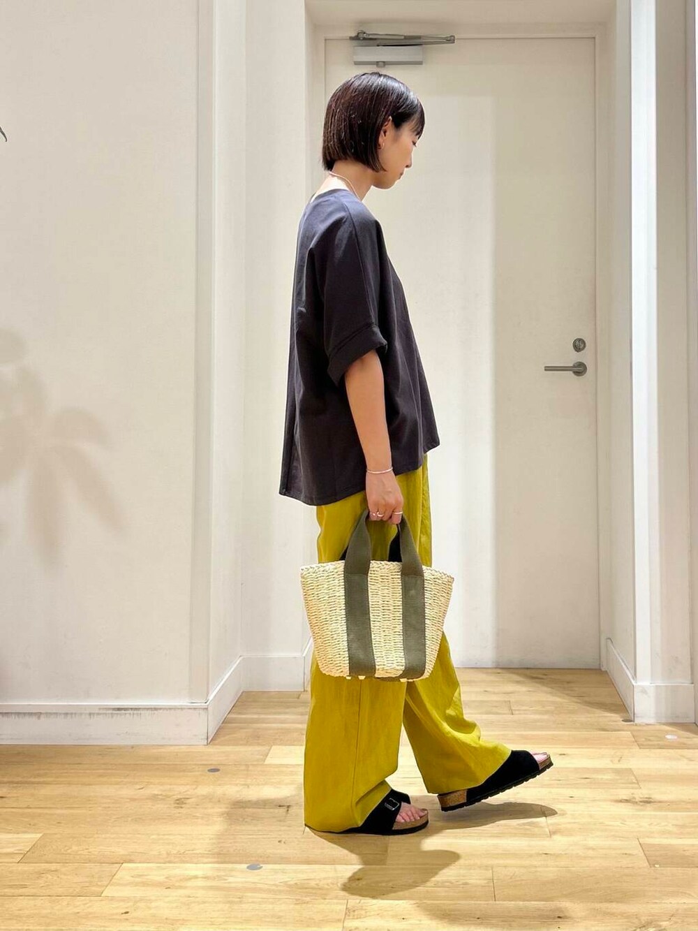 ベージュ系のかごバッグ、イエロー系のその他パンツ、ブラック系のサンダルを着用したレディースの夏コーディネートの4枚目の写真