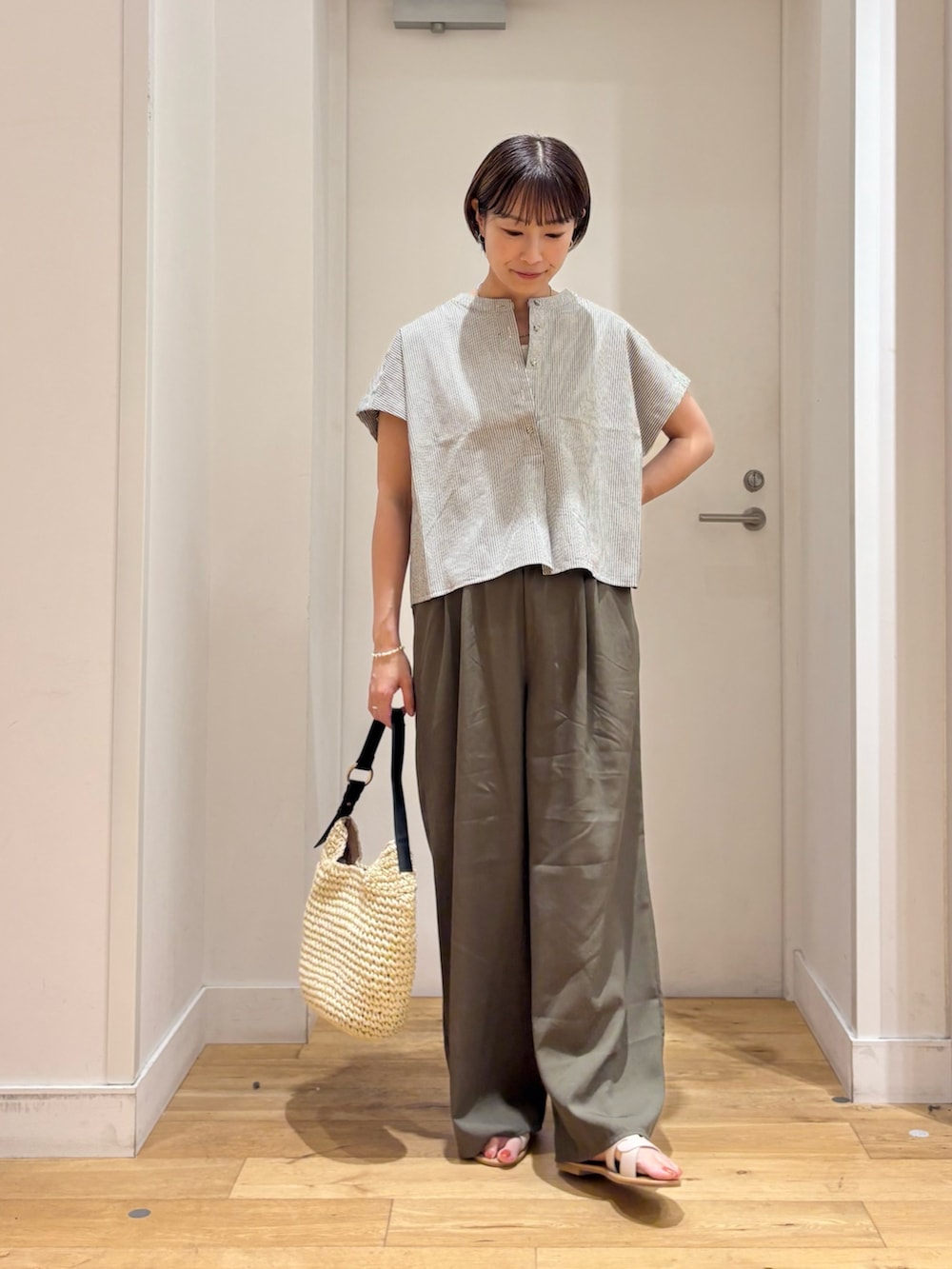 ブラック系のシャツ/ブラウス、グリーン系のその他パンツ、ベージュ系のトートバッグを着用したレディースの夏コーディネートの3枚目の写真