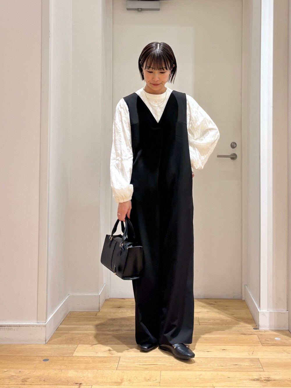 ブラック系のスーツジャケット、ホワイト系のシャツ/ブラウス、ブラック系のハンドバッグを着用したレディースの冬コーディネートの7枚目の写真