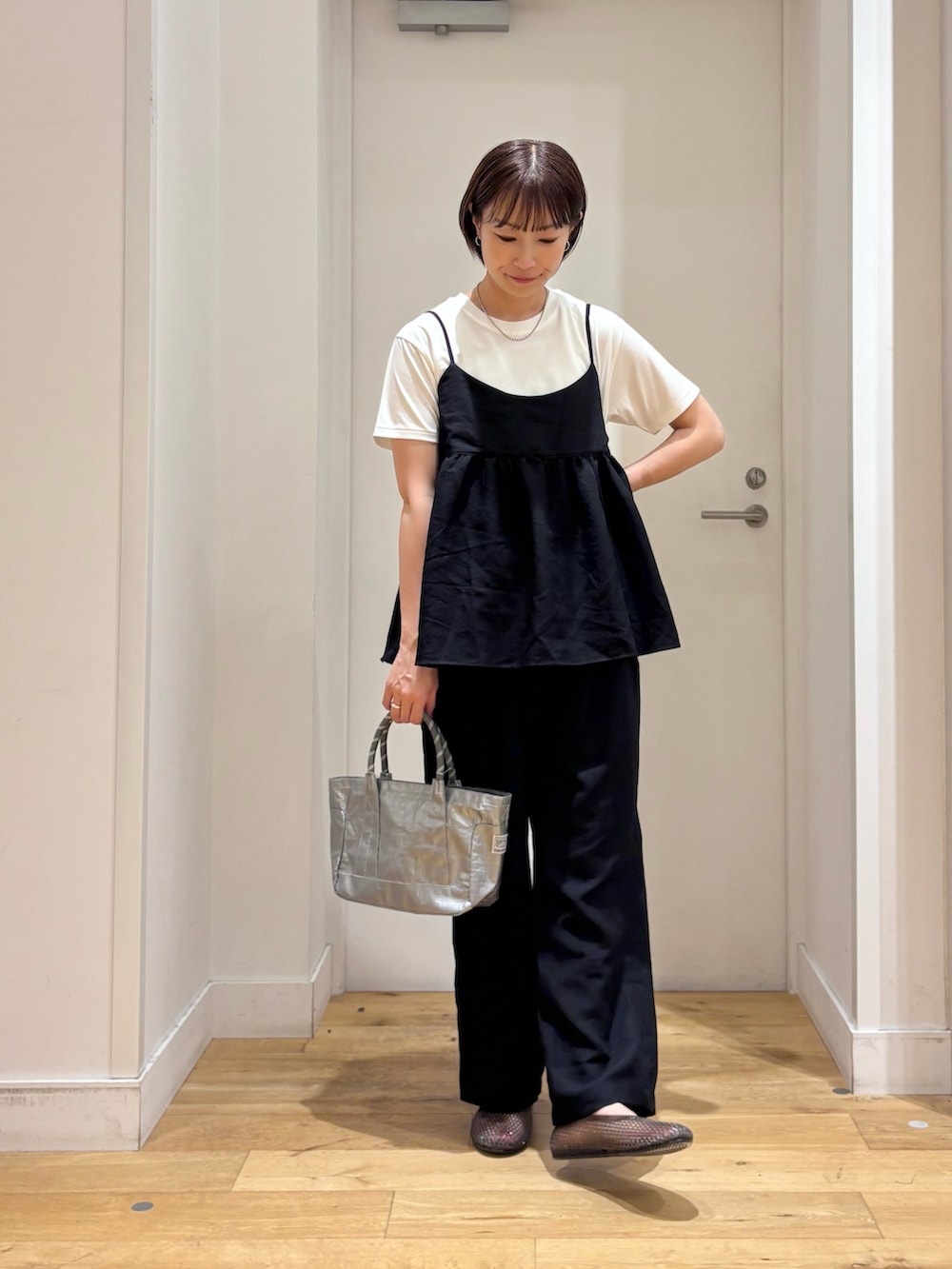 ブラック系のワンピース、ホワイト系のTシャツ/カットソー、シルバー系のショルダーバッグを着用したレディースの夏コーディネートの2枚目の写真
