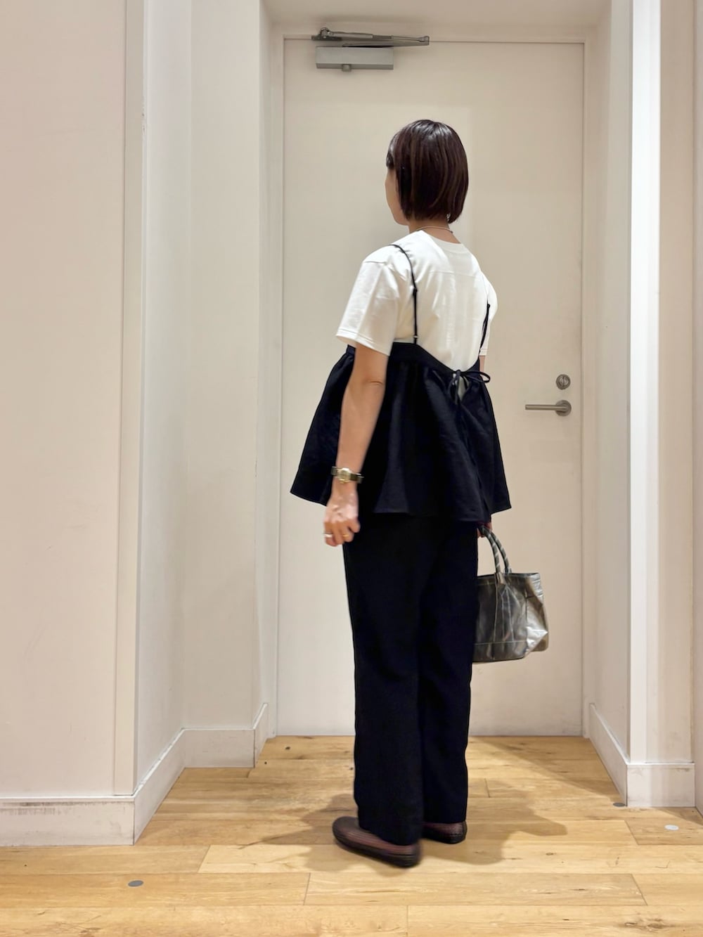 ブラック系のワンピース、ホワイト系のTシャツ/カットソー、シルバー系のショルダーバッグを着用したレディースの夏コーディネートの5枚目の写真