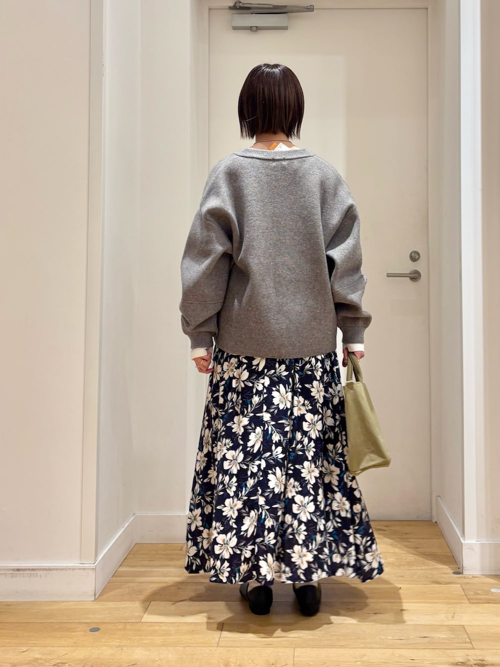 グリーン系のニット/セーター、ホワイト系のTシャツ/カットソー、ブルー系のスカートを着用したレディースの冬コーディネートの6枚目の写真