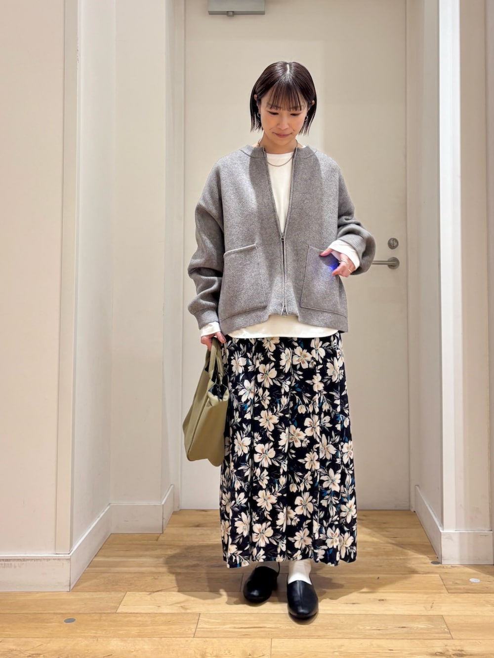 グリーン系のニット/セーター、ホワイト系のTシャツ/カットソー、ブルー系のスカートを着用したレディースの冬コーディネートの4枚目の写真